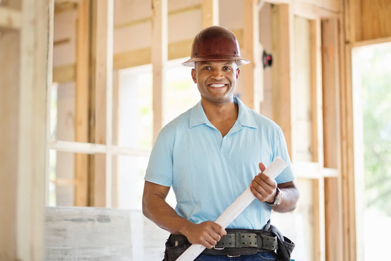 Engineer holding blueprint at construction site.