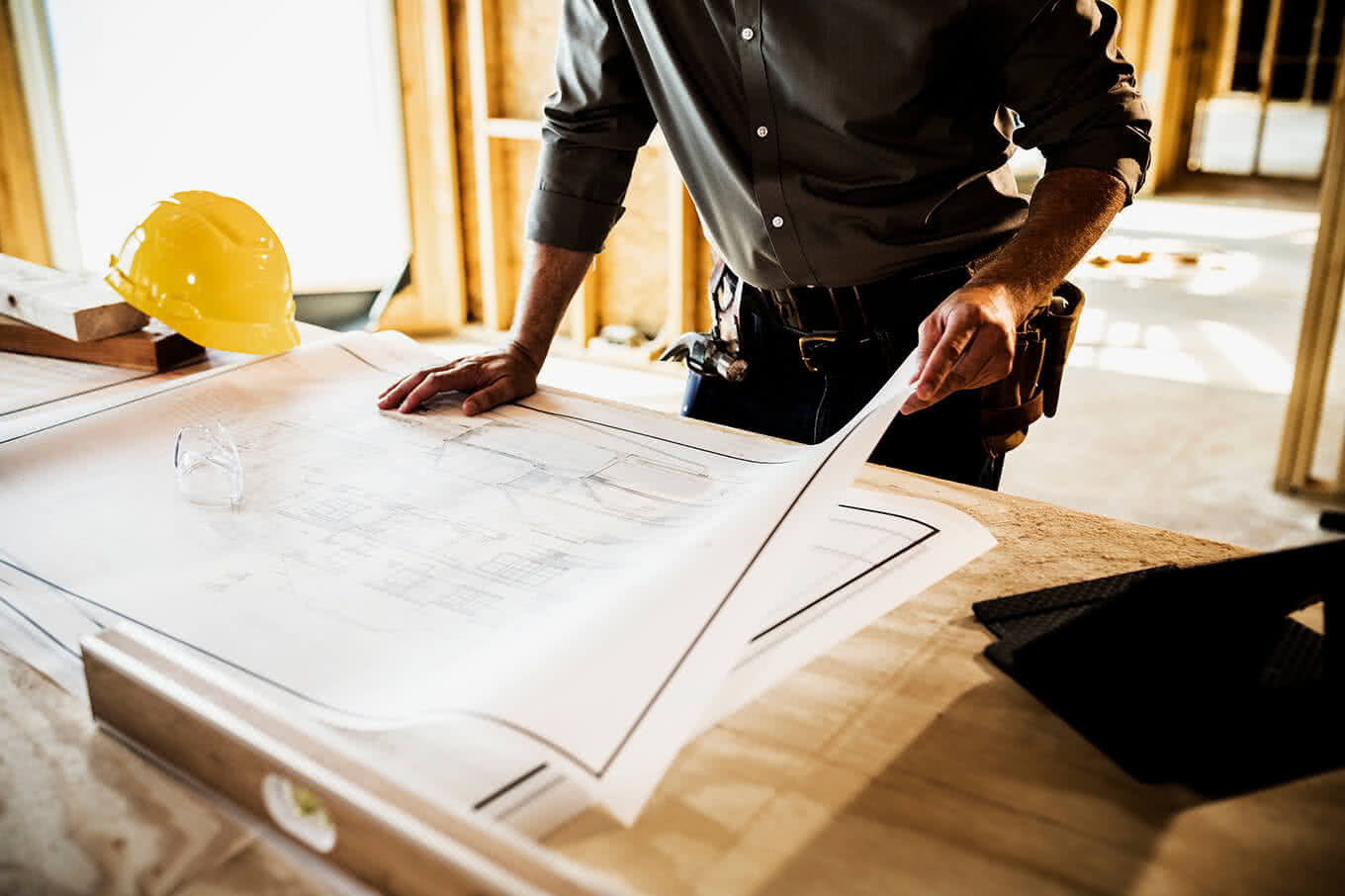 Inspector going over plans for home building at contruction site.